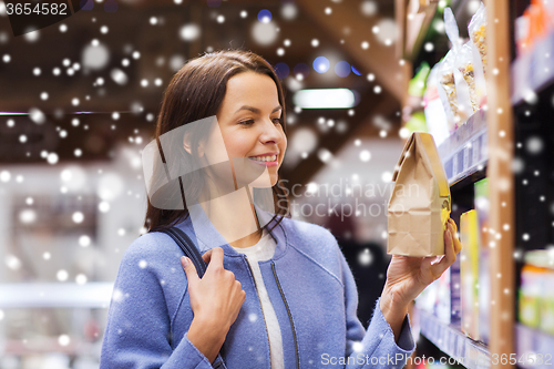 Image of happy woman choosing and buying food in market