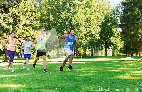 Image of happ young sportsmen racing wit badge numbers