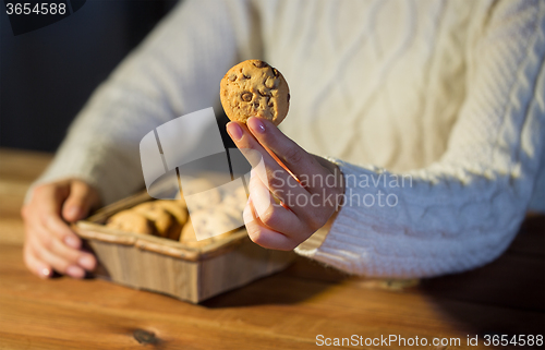 Image of close up of woman with oat cookies at home