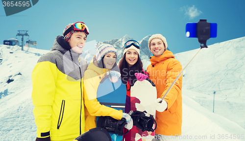 Image of happy friends with snowboards and smartphone