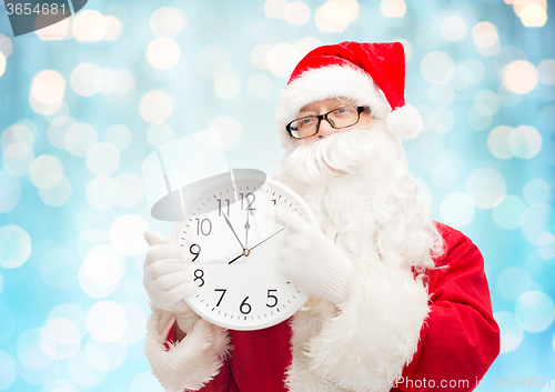 Image of man in costume of santa claus with clock