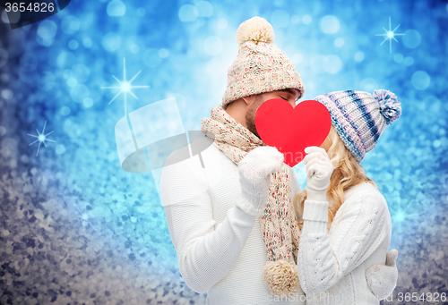 Image of smiling couple in winter clothes with red heart