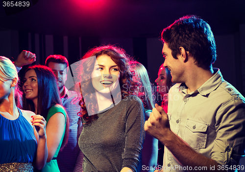 Image of smiling friends dancing in club