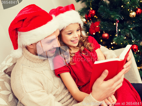 Image of smiling father and daughter reading book