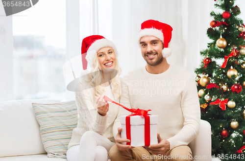Image of happy couple at home with christmas gift box