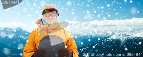 Image of happy young man in ski goggles over mountains