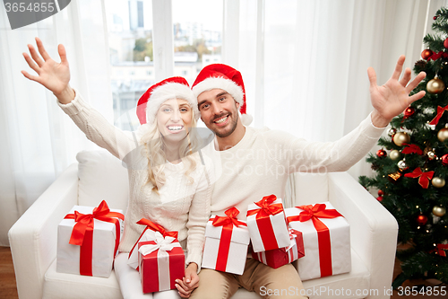 Image of happy couple at home with christmas gift boxes