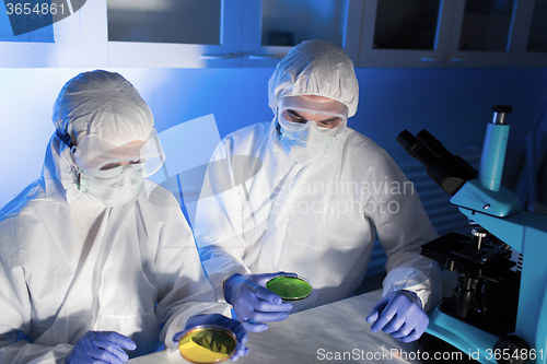 Image of close up of scientists with test samples in lab