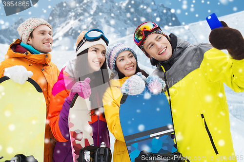 Image of happy friends with snowboards and smartphone