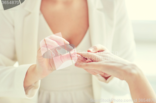 Image of close up of lesbian couple hands with wedding ring