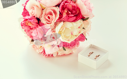 Image of close up of gay wedding rings and flower bunch