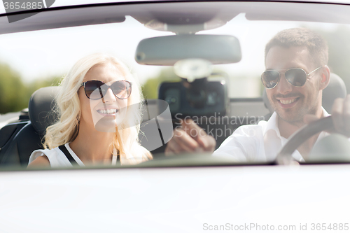 Image of happy couple usin gps navigation system in car