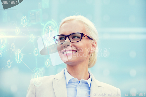 Image of young smiling businesswoman in eyeglasses outdoors