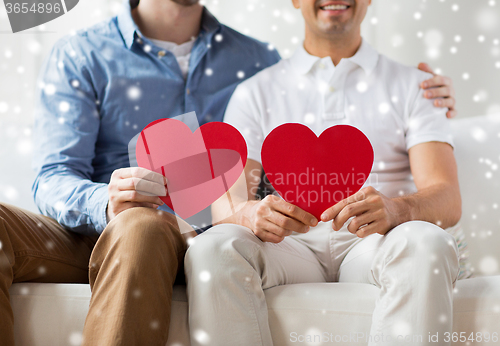 Image of close up of happy gay male couple with red hearts