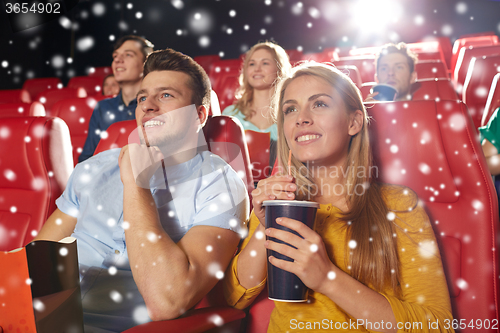 Image of happy couple with popcorn and drink in cinema