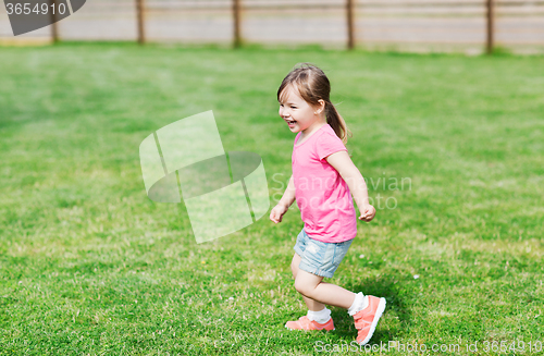 Image of happy little girl running on green summer field