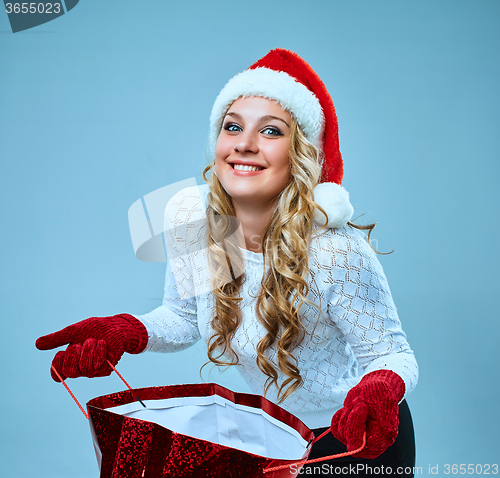 Image of Beautiful young woman in Santa Claus clothes