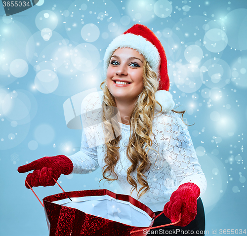 Image of Beautiful young woman in Santa Claus clothes