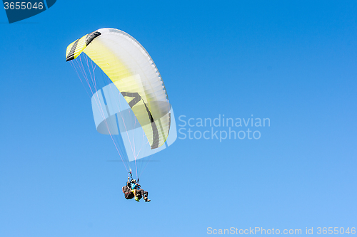 Image of Paragliding sport flight on soaring wing in clear blue sky