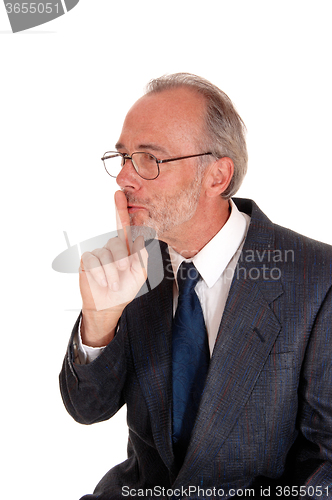 Image of Businessman giving sign with finger over mouth.