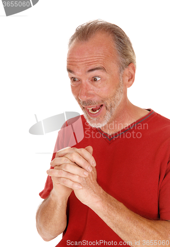 Image of Exited older man hands folded.
