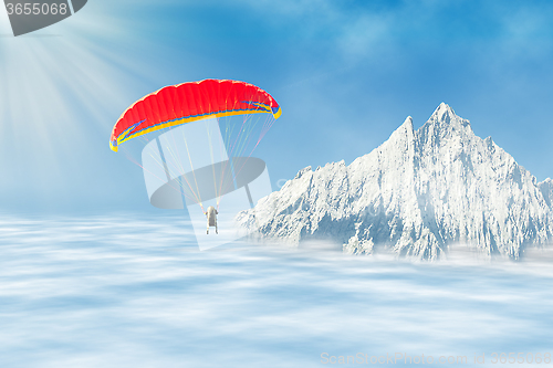 Image of Freestyle solo paragliding over clouds against mountain peak 