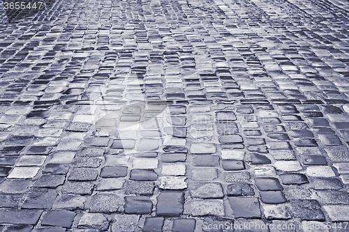 Image of Road with wet cobblestones in rainy weather