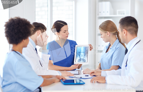 Image of group of doctors with x-ray on tablet pc at clinic