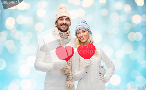 Image of smiling couple in winter clothes with red hearts