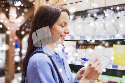 Image of happy woman with notepad in market