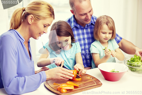 Image of happy family with two kids cooking at home