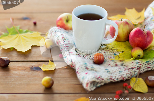 Image of close up of tea cup on table with autumn leaves