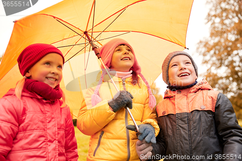 Image of happy children with umbrella in autumn park