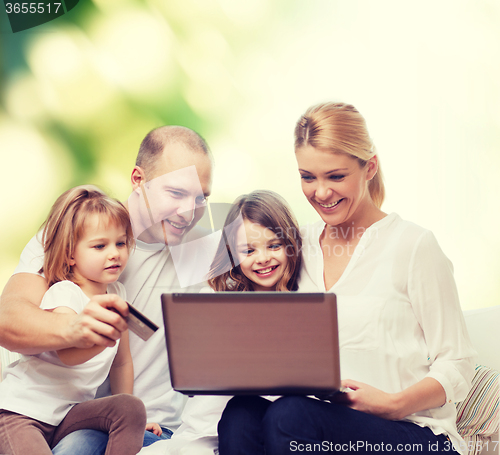 Image of happy family with laptop computer and credit card