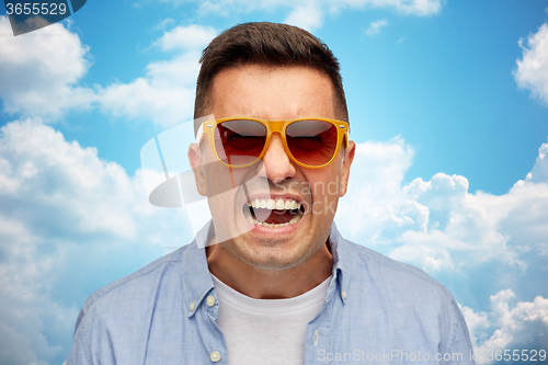 Image of face of angry man in shirt and sunglasses