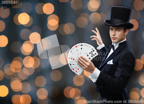 Image of magician showing trick with playing cards