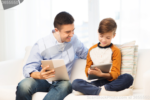 Image of happy father and son with tablet pc at home
