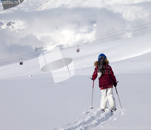 Image of Girl on skis in off-piste slope with new fallen snow at sun day