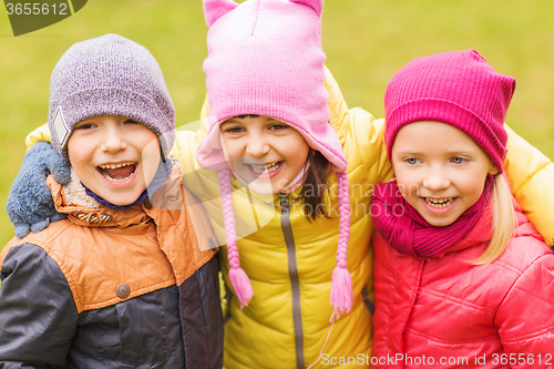 Image of group of happy children hugging in autumn park