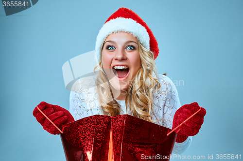 Image of Beautiful young woman in Santa Claus clothes