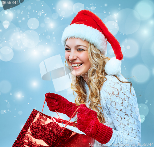 Image of Beautiful young woman in Santa Claus clothes