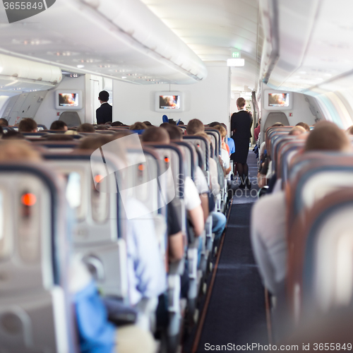 Image of Interior of airplane with passengers on seats.