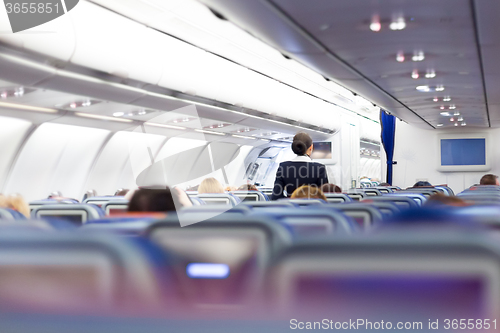 Image of Interior of airplane with passengers on seats.