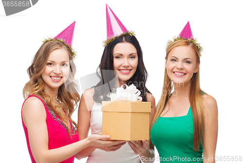 Image of three smiling women in blue hats with gift box