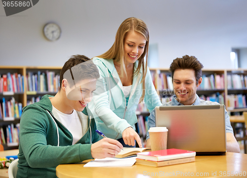Image of happy students with laptop and books at library