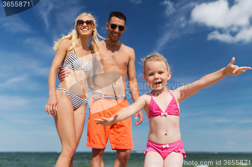 Image of close up of happy family with child on beach