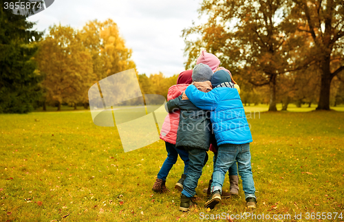 Image of group of happy children hugging in autumn park