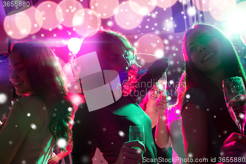 Image of smiling friends with glasses of champagne in club