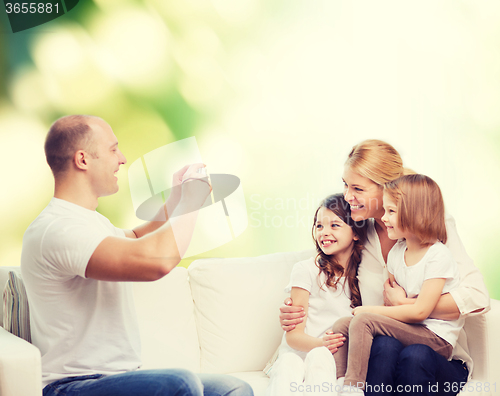 Image of happy family with camera at home