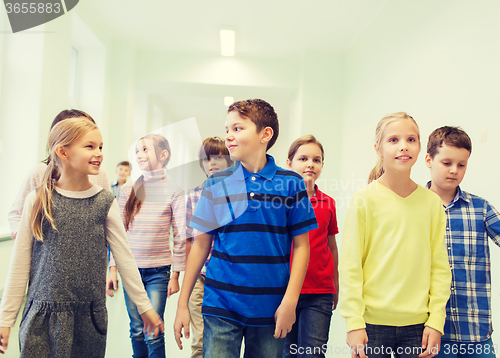 Image of group of smiling school kids walking in corridor